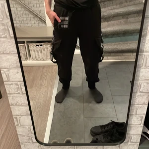 Svarta cargobyxor från New Yorker/Black Squad - Svarta cargobyxor från New Yorker. Byxorna har en loose passform och är tillverkade i ett slitstarkt material. Inte använt sen 2019-2020 säkert så säljer av dom.