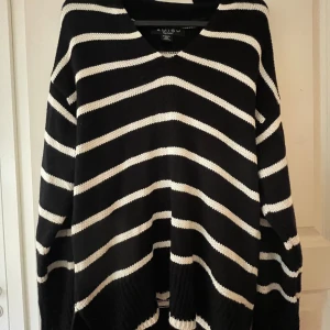 Svart och vit randig tröja från Amisu - Säljer en superfin svart och vit randig tröja från Amisu. Den är stickad och har en v-ringad hals. Perfekt för höst och vinter med sina långa ärmar och mysiga passform. Tröjan är i storlek XS och är i nyskick. Perfekt för en stilren och bekväm look!