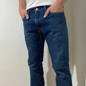 Levis 501 - Säljer ett par klassiska blå Levis 501 i en snygg straight fit. Perfekta för vardagsbruk och kan enkelt matchas med en t-shirt eller skjorta. 