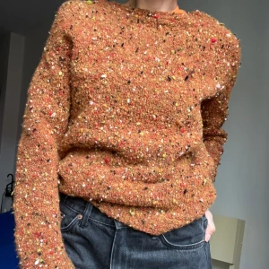 Tjock långärmad tröja - Rostbrun/orange- färgad tröja med mönstrade detaljer i gult, svart vitt och rött. Tror den är hemmastickad men väldigt välgjord. Skulle säga att det är en strl S. Mycket varm så tror det är ull. 