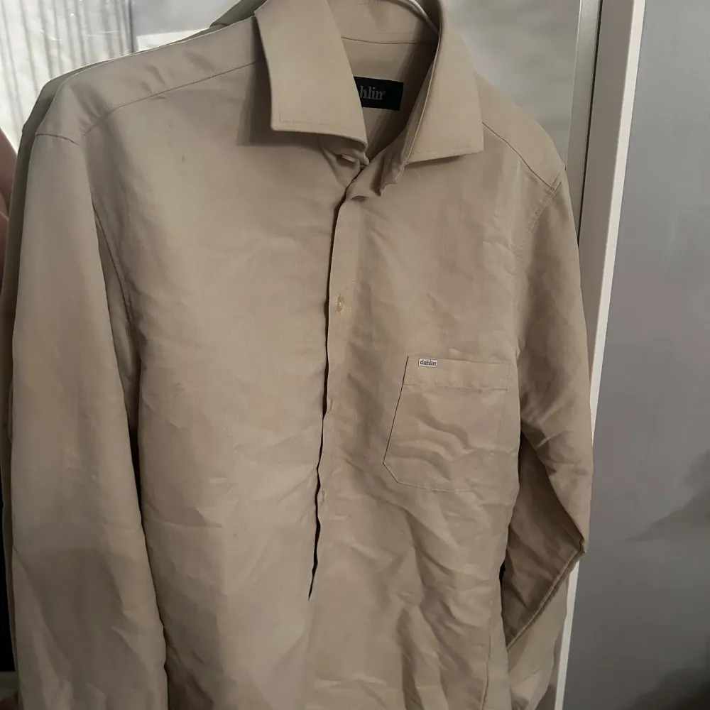 Beige herrskjorta i S från Dahlin. Jag är i vanliga fall M och den sitter bekvämt. Lite speciellt material. Inte sammet men inte vanligt ”skjorttyg”. Mjuk och len. Snygg till blå eller svarta jeans/byxor🌻. Skjortor.