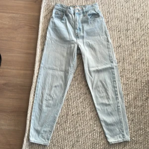 Ljusa jeans från Levi's - Säljer ett par ljusa jeans från Levi's. Modellen heter High Loose Taper. De är högmidjade och har en straight passform. Jeansen har fem fickor och vanlig gylf.