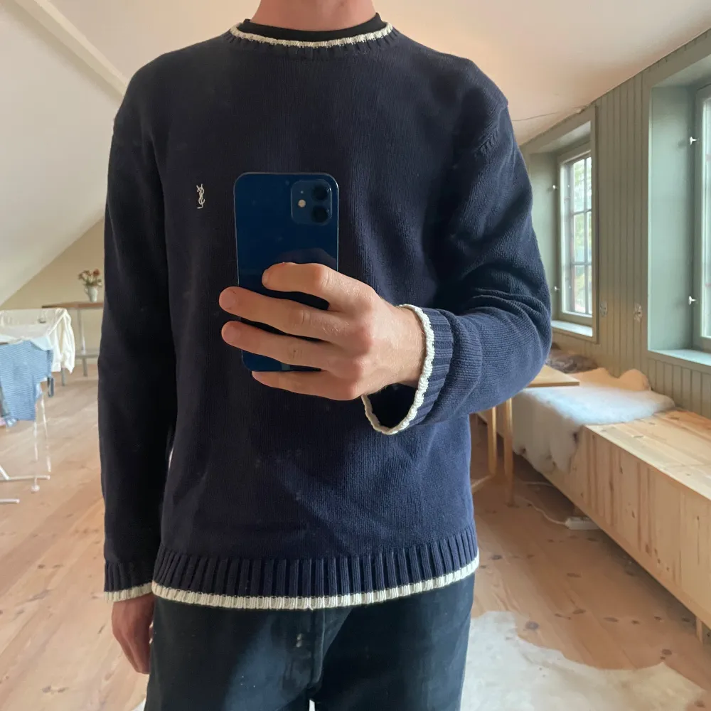 Ysl stickad tröja i mycket bra skick. Riktigt snygga detaljer med det vita och mörkblå vilket gör den till unik. Inga fläckar eller revor på tröjan. Modellen är 182 och 72 kg. Hör av dig vid frågor.. Stickat.