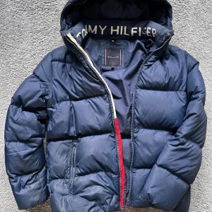 Blå Tommy hilfiger jacka - Fint skick, aldrig använd, köptes för 2000kr, vet inte vad jag ska sälja den för så kom gärna med bud och kontakta vid intresse😁 Den passar bra på dig som är 160-170