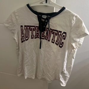 Vit tröja med text  - En vit t-shirt men en fin snörning storlek s sitter tajt men ändå inte för tajt 🥰