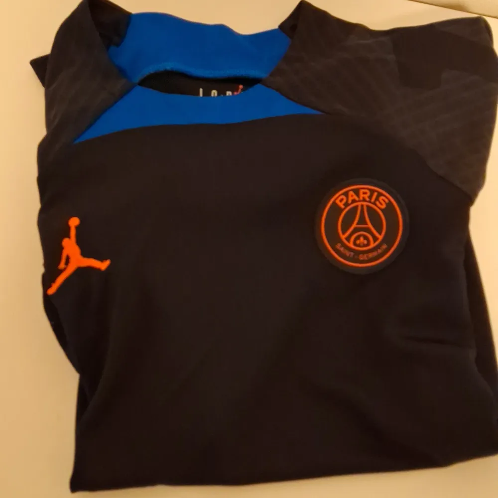 Svart psg tröja med orangea och blåa detaljer. Nästan aldrig använd men den är för liten för mig. Slim fit i storlek s. Sportswear.