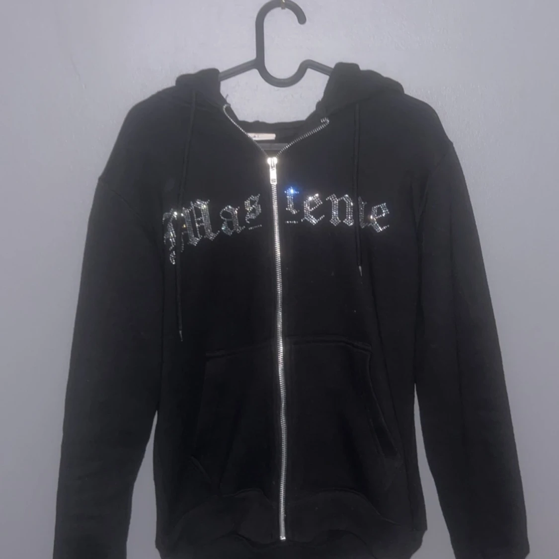 Svart hoodie med glittrig text och motiv