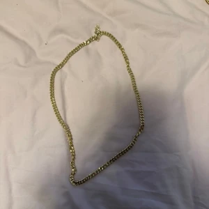 Guldfärgat halsband - Elegant guldfärgat halsband med en klassisk kedjedesign. Perfekt för att lägga till en touch av stil till vilken outfit som helst.