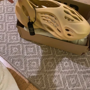 Gula sandaler från Adidas - Säljer ett par gula sandaler från Adidas med unik design och vågformad sula. Perfekta för sommarens äventyr. De är lätta och bekväma att bära.