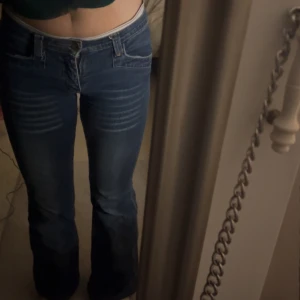 Blå Lågmidjade bootcut jeans - Snygga blå bootcut jeans med låg midja och klassisk femficksdesign. Perfekta för en avslappnad stil med en touch av retro. Passar dig som är 150-156 ish. 32/34 i strl. 