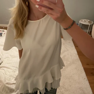 Vit blus med volangdetaljer - Superfin zarablus med volang detaljer! Säljer då den tyvärr är för stor, strl S men skulle säga att den snarare passar M. Passar lika till vardags som till helgen💓