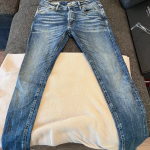 Blå jeans från Jack & Jones - Säljer ett par snygga blå jeans från Jack & Jones, modell Spray On/Tom. Perfekta för en stilren look! Priset kan diskuteras vid köp av alla tre jeans i min shop, annars 100kr st, byxorna är nästan sprillans nya testade en gång 