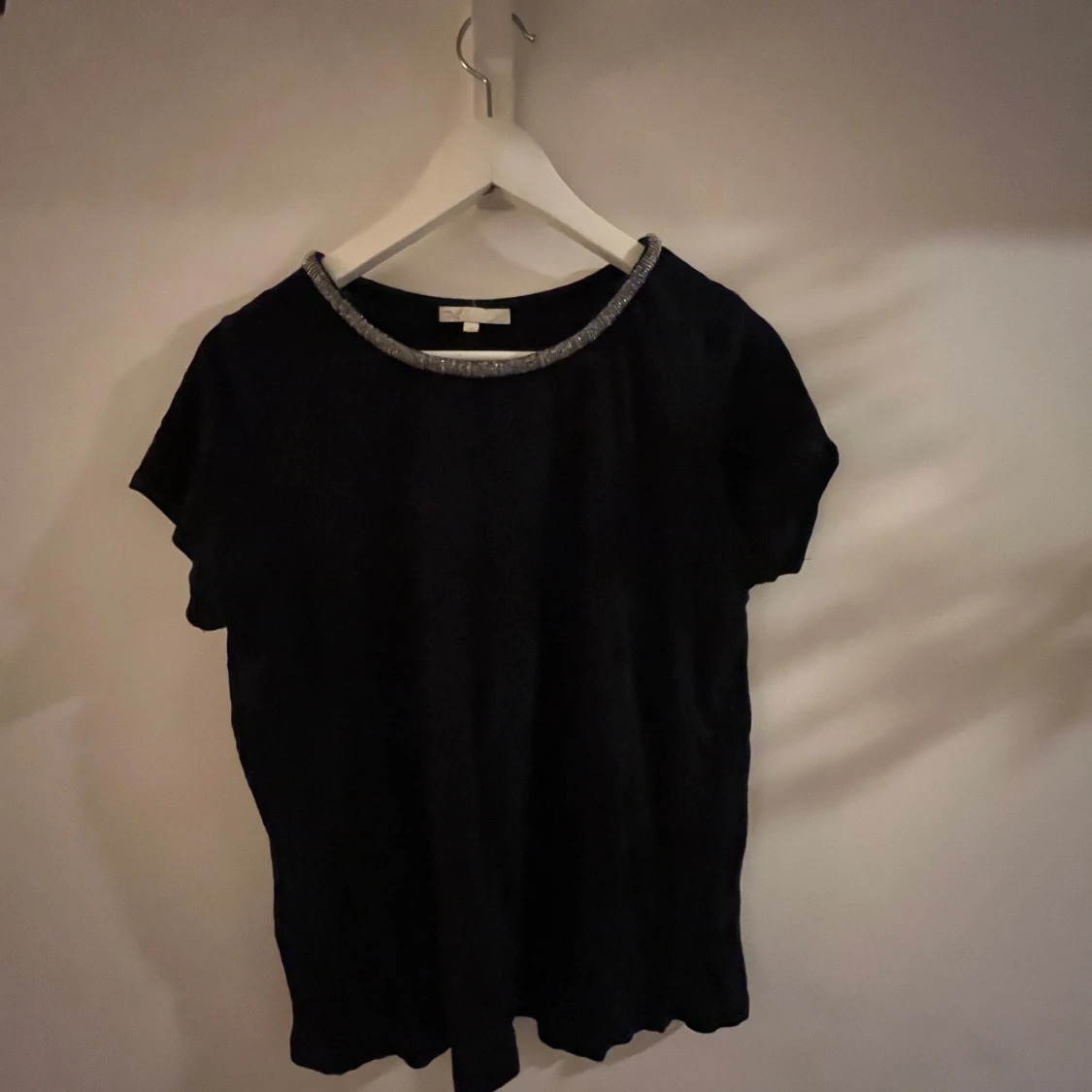 Svart topp med glittrig halsringning - 90