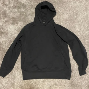 Svart hoodie från Uniqlo - Säljer en stilren svart hoodie från Uniqlo i storlek L. Som man kan se på bilderna är den lite urtvättad och saknar snöret. 