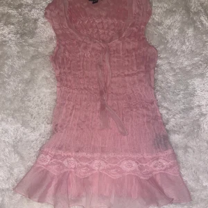 Rosa topp  - Snygg rosa topp/blus, lite genomskinlig o lite glittrig. Den ser lång ut på bilden men är typ under naveln