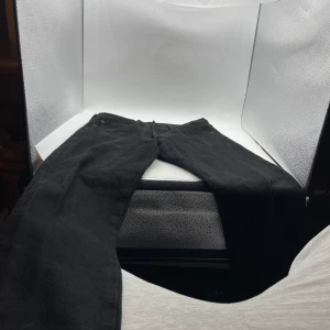 Svarta jeans från Levi's - Snygga svarta jeansbyxor från Levi's med klassisk femficksdesign och knappgylf. Perfekta för en stilren look. W 31 L 32, 