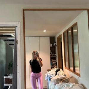 Rosa jeansbyxor - Snygga rosa jeansbyxor med en tight passform. Perfekta för att lägga till en färgklick i garderoben. De har en klassisk design med knappar och dragkedja framtill.