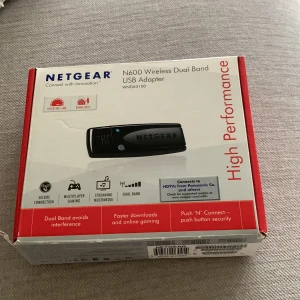 Netgear N600 Wireless Dual Band USB Adapter - Netgear N600 Wireless Dual Band USB Adapter för snabb och stabil internetanslutning. Perfekt för streaming och gaming med dual band-teknologi som minskar störningar. Enkel installation med 'Push 'N' Connect' knapp för säker anslutning.