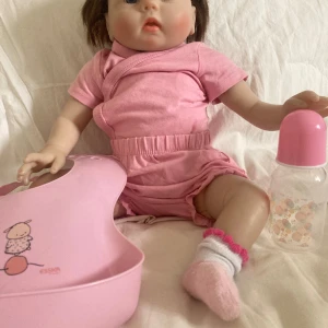 Reborndocka/ Fin docka!  - En fin docka i bra skick! Dockan har tyg kropp med silikon delar. Den säljs med kläderna den har på sig, nappflaska och haklapp (allt köpt till dockan). Orginal pris ca 400/500kr Säljs för 175kr men priset kan diskuteras. 