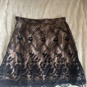 Spets kjol - En äldre Hennes kjol med svart spetsdetalj. Storlek M