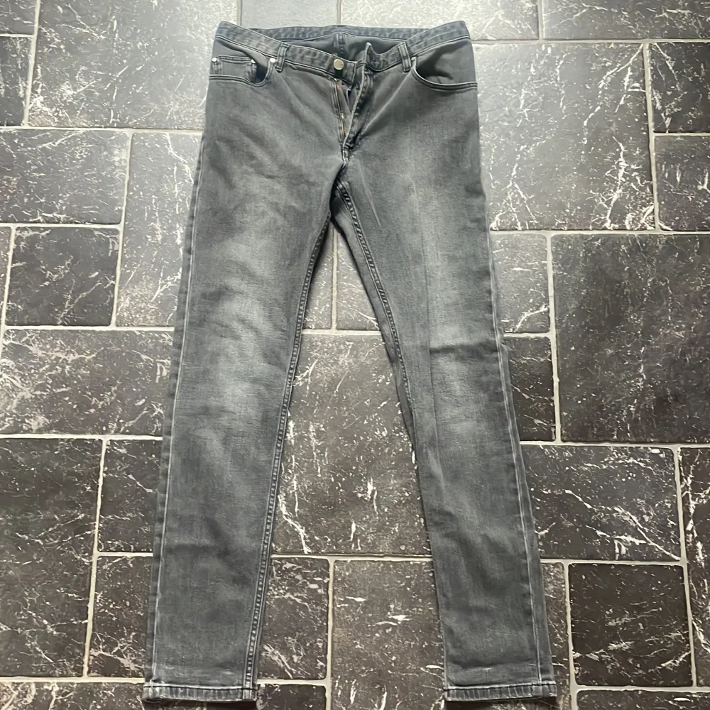 Säljer ett par snygga grå jeans från Whyred. De har en slim passform och är perfekta för både vardag och fest. Jeansen har en klassisk femficksdesign och en knappgylf. De är i bra skick och redo för en ny ägare!. Jeans & Byxor.