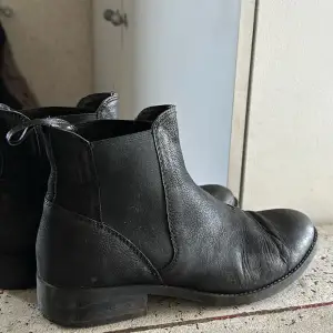 Säljer ett par svarta Chelsea boots i skinn från Vagabond. De har en klassisk design med elastiska paneler på sidorna för enkel på- och avtagning. Perfekta för både vardag och fest! Använda men har mer att ge. 