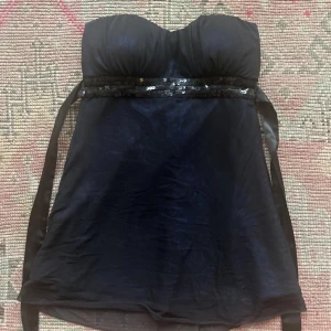 Glittrig tube topp - Använt en gång därefter i bra skick. Under tyget är det ett ytligare lager av tyg i blå färg och med  mönster 