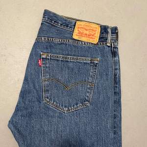 Säljer ett par klassiska Levi's 501 jeans i blå denim. De har en straight passform och är tillverkade i slitstarkt bomullsmaterial. Perfekta för både vardag och fest! Jeansens ikoniska design  gör dem tidlösa och mångsidiga. Sitter som 33/32.