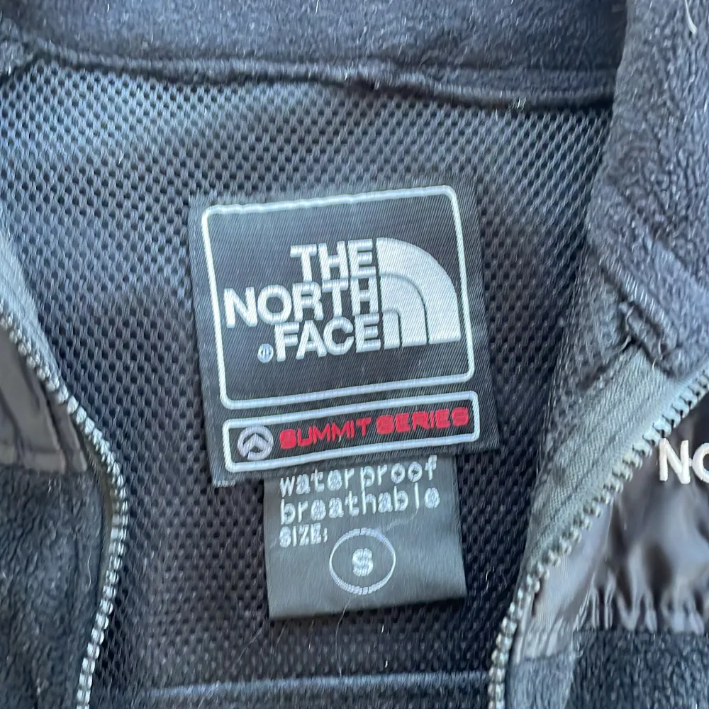 Säljer en svart fleecejacka från The North Face, Summit Series. Jackan är i nyskick och har en dragkedja framtill. Den är perfekt för höst och vår, med långärmade ärmar och en skön passform. Materialet är fleece, vilket gör den både varm och bekväm. Perfekt för utomhusaktiviteter!. Jackor.