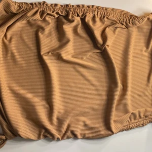 Brun/beige kjol - Snygg brun/beige med knytband. Perfekt för sommarens stranddagar. Den har en elastisk midja för en bekväm passform.