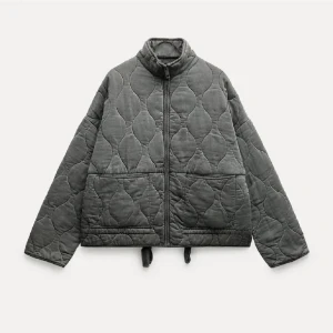 Grå quiltad jacka från Zara - Säljer en grå quiltad jacka från Zara med dragkedja framtill. Jackan har en hög krage och långa ärmar. As najs på vår o höst osv