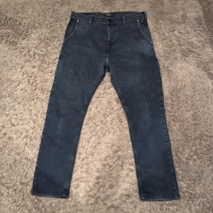 Mörkblå jeans från Replay slim fit - Snygga mörkblå jeans från Replay med klassisk femficksdesign. De har en knappgylf och bälteshällor. Perfekta för en stilren look. Riktigt feta med extra detaljer. Först till kvarn!         Storlek L27 W30
