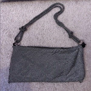 Glittrig axelväska med dragkedja - Snygg glittrig axelväska med ett coolt rutigt mönster. 