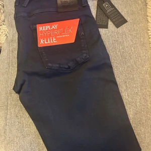 Replay Anbass Hyperflex X-Lite - Helt nya, oanvända Replay Hyperflex X-Lite jeans i modellen Anbass. W30 L32. Alla lappar/taggar kvar, inte ens provade. De har en slim passform. Perfekta för en stilren look.