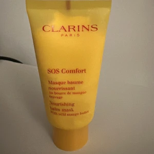 Clarins SOS Comfort Nourishing Balm Mask - Clarins SOS Comfort är en närande balm-mask med vild mangosmör. Perfekt för att ge huden extra fukt och näring. Applicera på ansikte och hals, undvik ögonområdet, och låt verka i 10 minuter. Skölj av med ljummet vatten. Användt endast en gång! Ny pris runt 400 kr.