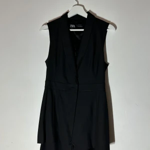 Klänning från Zara - Elegant svart ärmlös klänning från Zara med en stilren design. Klänningen har en djup v-ringning och ett bälte i midjan för en smickrande passform. Perfekt för en chic och modern look.🥰🥰🥰
