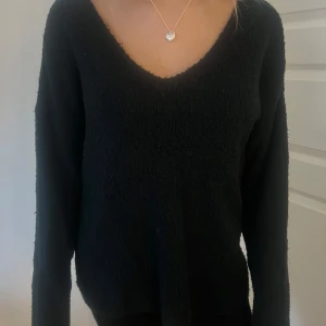 Svart stickad tröja - Säljer en mysig svart stickad tröja med v-ringning. Tröjan har långa ärmar och är perfekt för kyligare dagar. Passar bra till både jeans och kjol. Perfekt för höst och vinter!