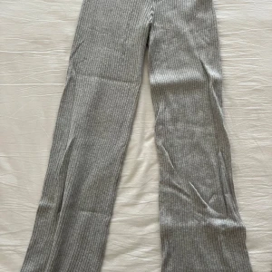 Grå ribbade byxor - Snygga grå ribbade byxor med en bekväm passform. Perfekta för en avslappnad stil och kan enkelt matchas med olika toppar. Byxorna har en rak design och är tillverkade i ett mjukt material.