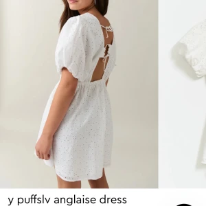 Vit klänning med puffärmar - Supersöt vit klänning med puffärmar och broderat mönster. Den har en öppen rygg med knytning och en kort längd. Perfekt för studenten och somriga tillfällen