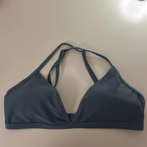 Blå/grön bikiniöverdel från Shein - Snygg blå/grön bikiniöverdel från Shein med korsade band i ryggen och en stilren design. Enkel att matcha med olika underdelar.