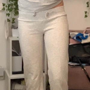 Grå mjukisbyxor från Gina Tricot - Säljer ett par bekväma grå mjukisbyxor från Gina Tricot. Byxorna har en ribbad midja med snörning och är perfekta för en avslappnad stil. De är tillverkade i mjukt material som känns skönt mot huden. Storlek146/152 barn men passar mig som har XS-S