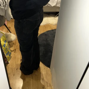 Svarta jeans med fransade kanter - Snygga svarta jeans med en avslappnad passform och fransade kanter vid bensluten. Mid waist/ high waist Jeansen har en klassisk femficksdesign och är perfekta för en casual look. De har en lätt slitning för en trendig touch. 