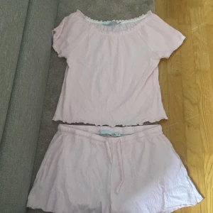 Ljusrosa set med shorts och topp - Säljer ett ljusrosa set från 157 i storlek S. Setet består av shorts och en matchande topp. Materialet är mjukt och bekvämt, perfekt för varma dagar. Shortsen har en elastisk midja med knytband för justerbar passform. Shortsen är använda typ 2 gånger och toppen är helt oanvänd! Hör av er vid intresse, tack!🥰💞