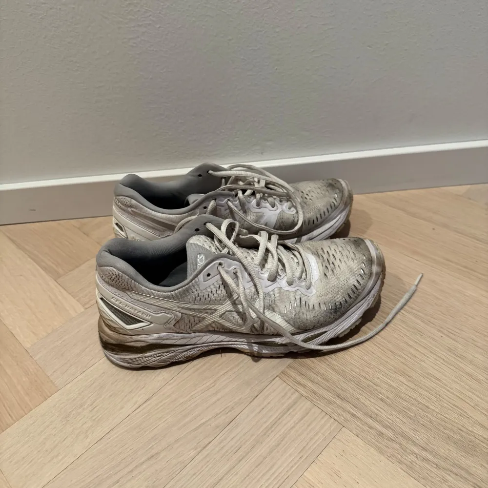 Säljer ett par vita löparskor från Asics i modellen gel kayano. De har snörning och en bekväm passform, perfekt för träning. Skorna har en robust sula med bra grepp, men är lite smutsiga efter användning. Perfekta för dig som vill ha ett par pålitliga träningsskor utan att spräcka budgeten. Innersulorna helt oanvända då jag haft andra sulor till. Välanvända men har fortfarande mycket kvar att ge.. Skor.