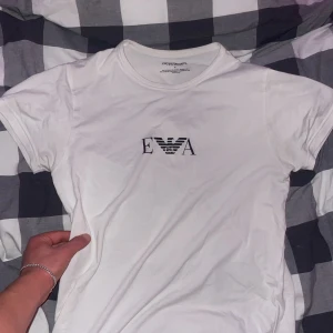 Vit t-shirt från Emporio Armani - Säljer en stilren vit t-shirt från Emporio Armani. T-shirten är i bra skick och har en normal passform. Använd edast några gånger! Så den är som ny. 