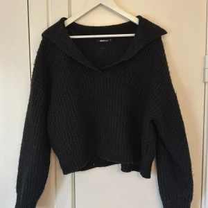 Svart stickad tröja från Gina Tricot - Säljer en svart stickad tröja från Gina Tricot i storlek M. Tröjan har en djup v-ringning och långa ärmar, perfekt för höst och vinter. Den är både stilren och bekväm, idealisk för att hålla sig varm och snygg under kyliga dagar.