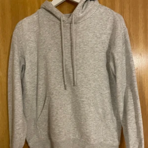Grå hoodie i bomull - Säljer en bekväm grå hoodie i bomull. Perfekt för kyliga dagar eller mysiga hemmakvällar. Den har en klassisk passform med känguruficka och justerbar huva. Ett måste i garderoben! 🩶