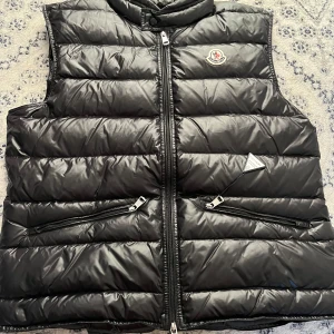 Svart dunväst Moncler - Säljer en snygg svart dunväst från Moncler i mycket bra skick. Den är i storlek 2 vilket motsvarar S-M. Skriv pm vid frågor eller funderingar.