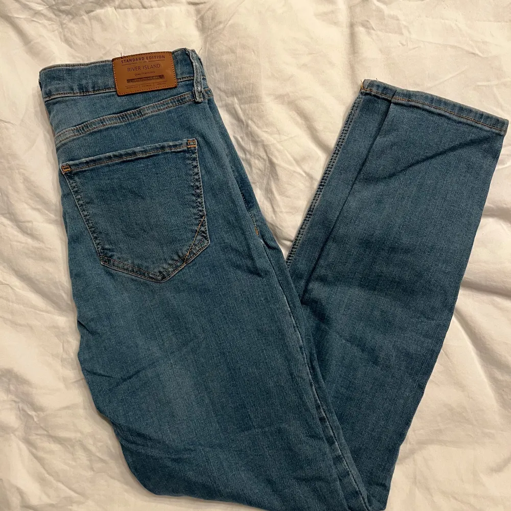 Säljer ett par snygga blå jeans från River Island i storlek EUR 38. De är i bra skick och har en klassisk skinny fit. Perfekta för både vardag och fest! 🥳. Jeans & Byxor.