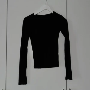 Svart långärmad - Svart långärmad topp med slits vid händerna i storlek xs